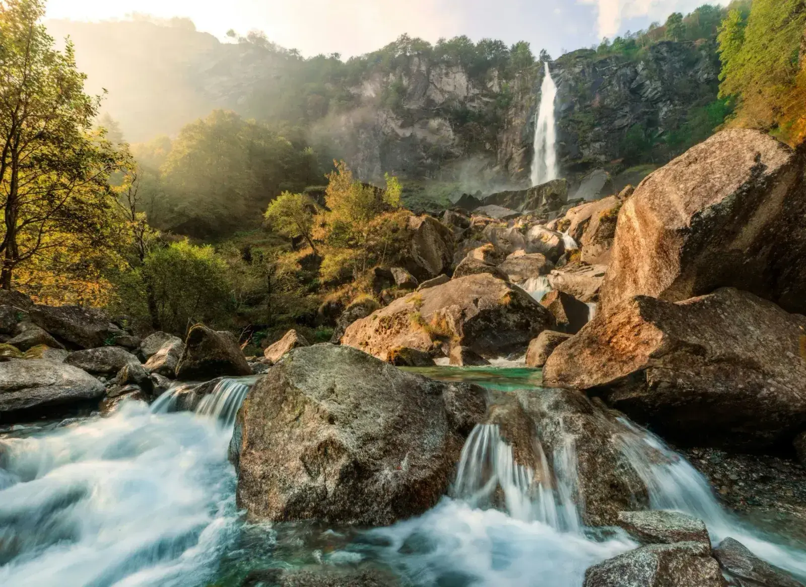 A waterfall pouring over mossy rock into a clear pool