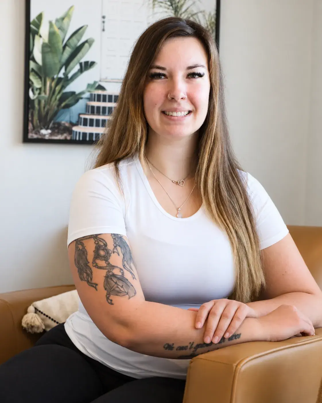 Dallas Nizalik, Registered Massage Therapist and Lymphatic Therapist at Renu, seated in the clinic lounge
