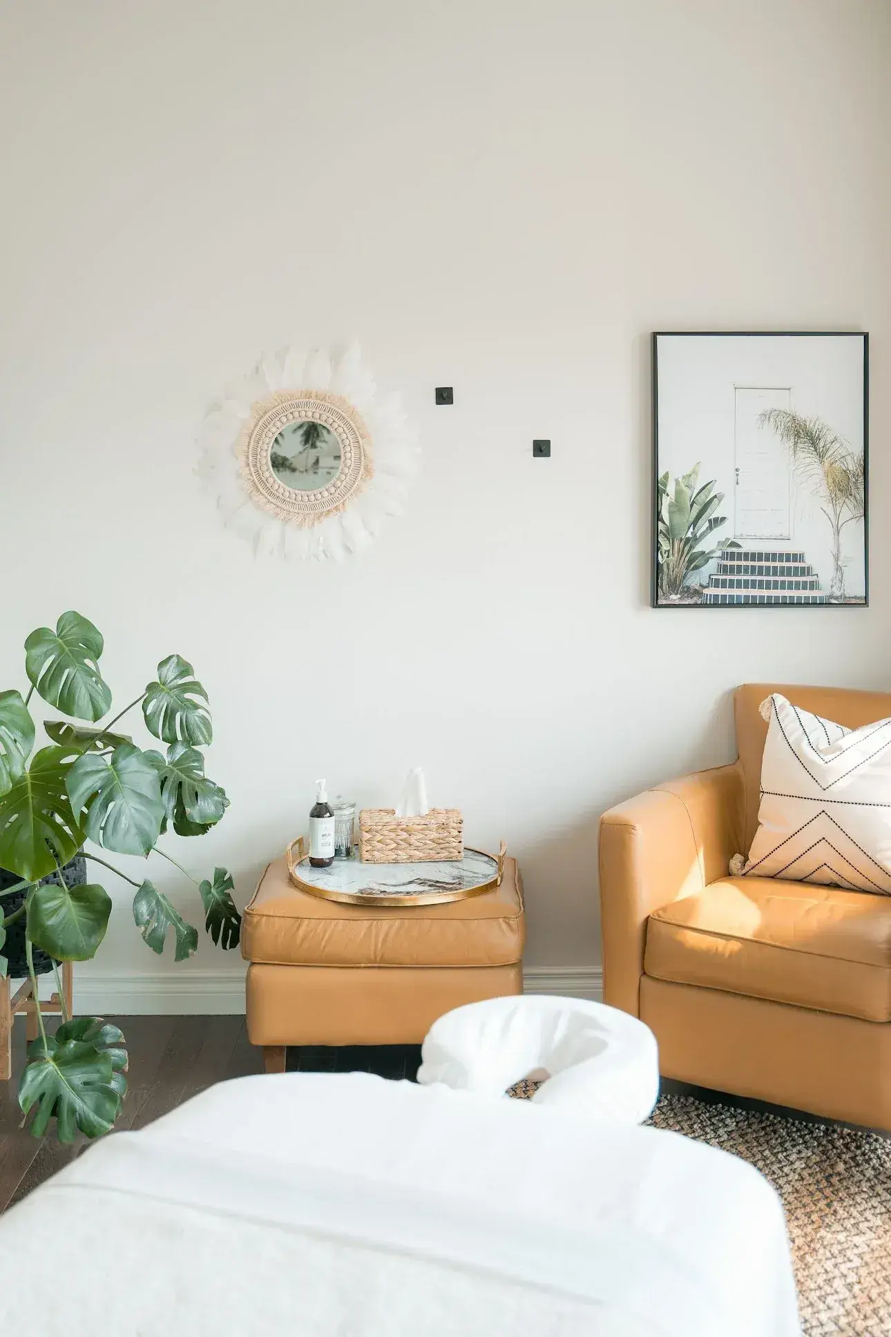 The Renu lounge with tan leather armchairs and plants, where clients can sit for a few minutes after treatment