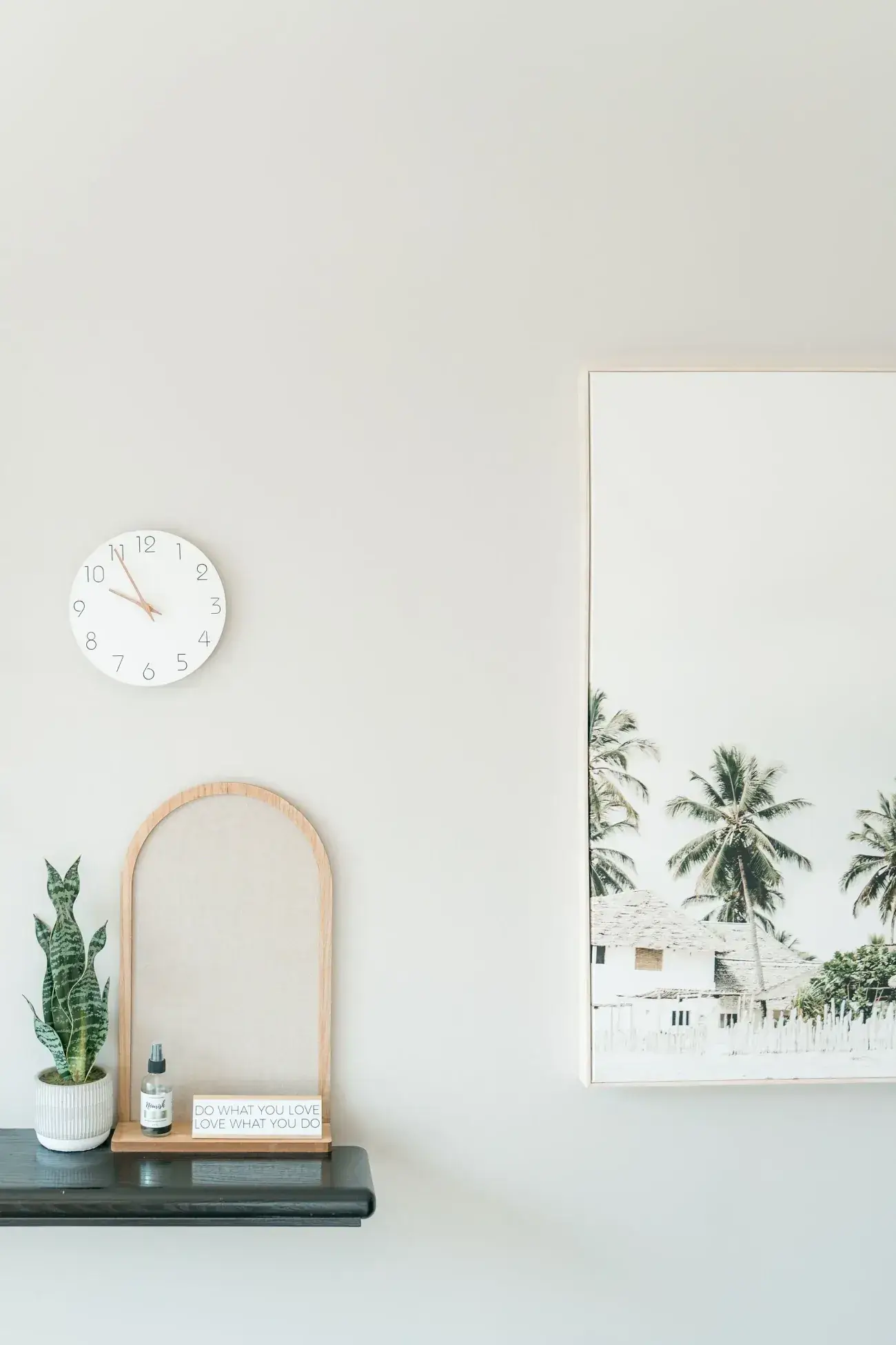 A wall clock, an arched mirror and a palm print in a bright treatment room at Renu