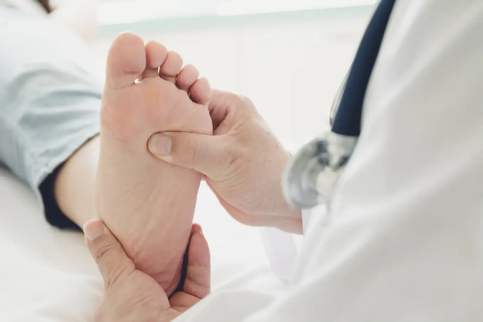 A clinician holding and examining the sole of a client's bare foot
