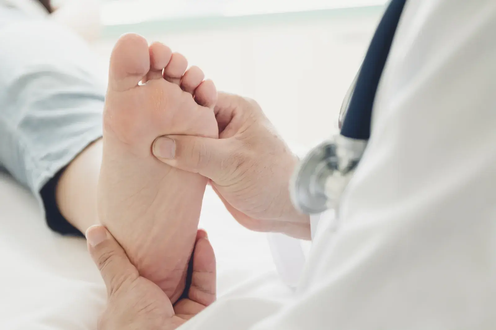 A clinician holding and examining the sole of a client's bare foot
