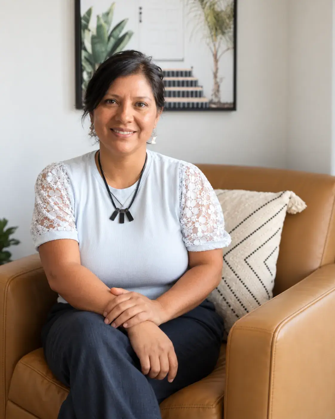 Yeni Soberanis, Registered Massage Therapist at Renu Health & Wellness, seated in the clinic lounge